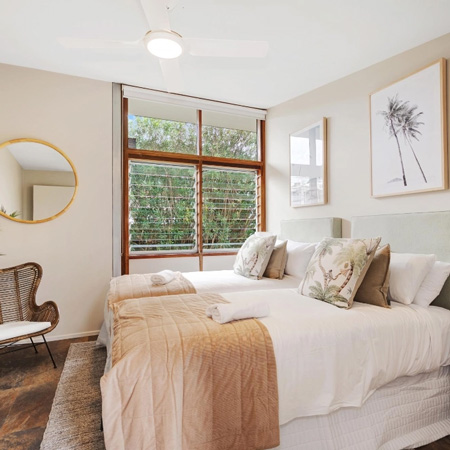 Bedroom with two beds, and warm coloured linen