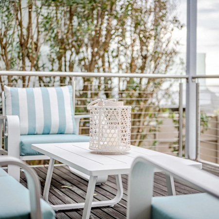 Airy beach fronting deck with blue and white chairs