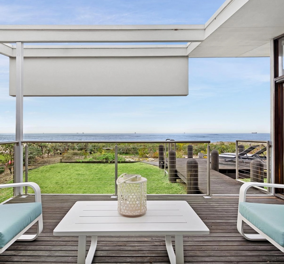 Airy deck with seating and a view out to dunes and water